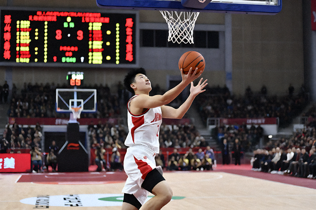 室内篮球馆比赛现场，球员上篮与记分牌画面